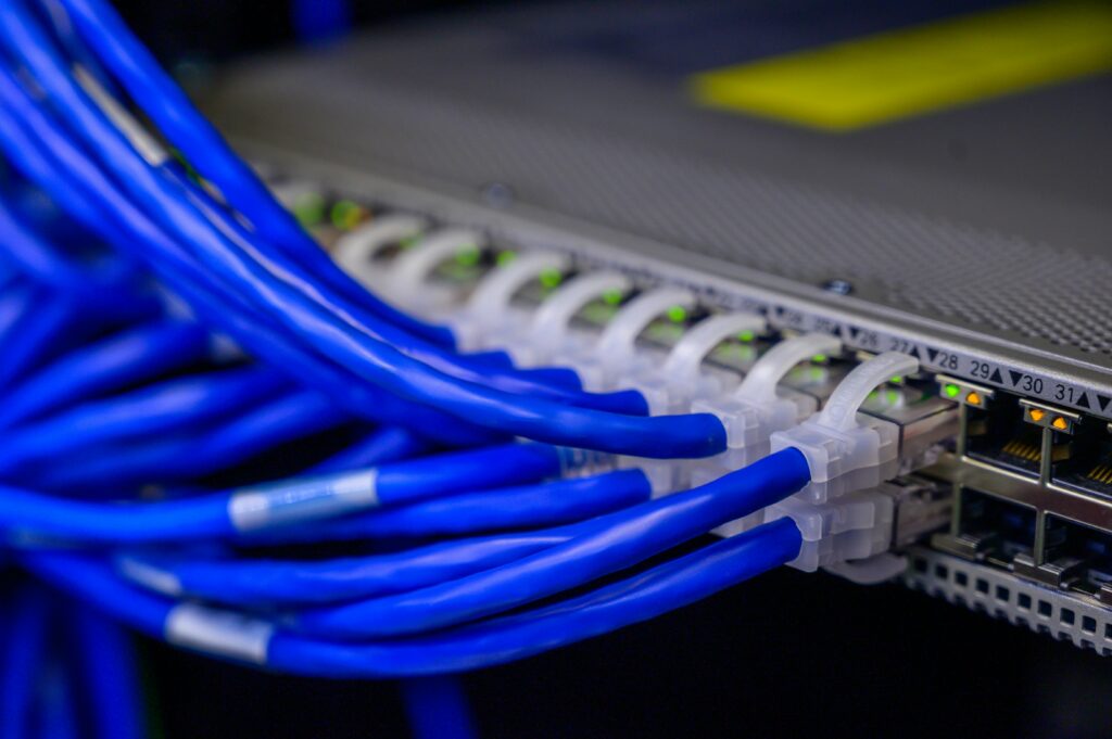 pexels photo 2881232 2881232 1 Detailed view of blue ethernet cables connected to a network switch in a data center.